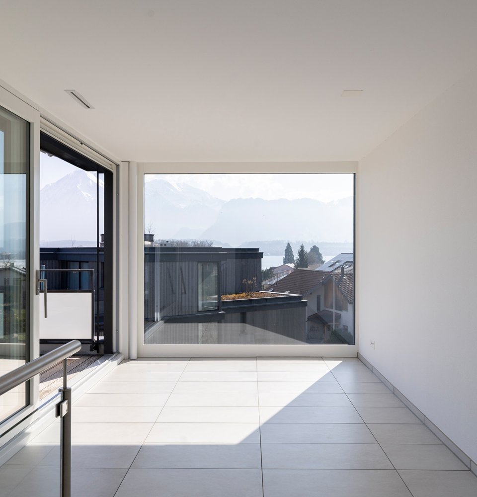 Raum im Obergeschoss mit grossem Fenster und Blick auf den Thunersee und die Berge